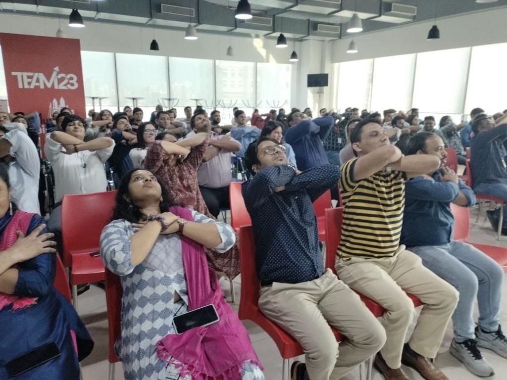 Employees doing neck stretches at corporate wellness session